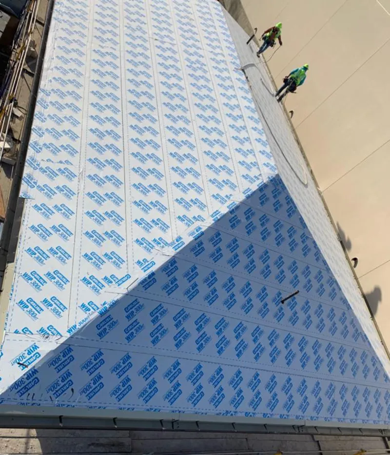 Professional roofers installing underlayment on a metal roof in Fayetteville